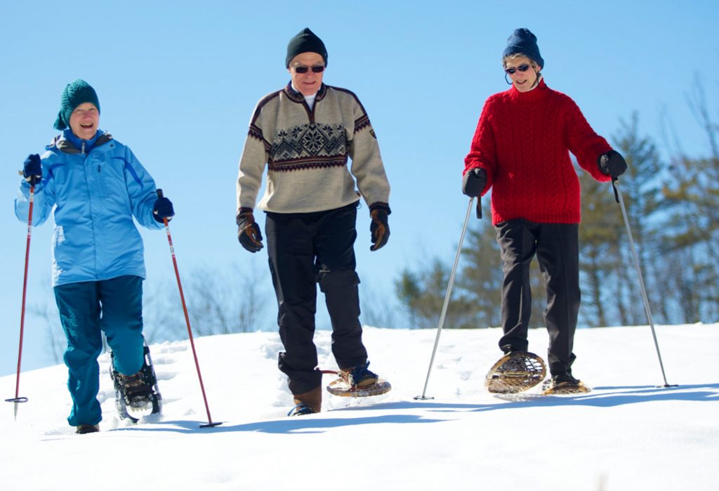 Three active independent living residents snowshoeing and crosscountry skiing at RiverWoods Exeter in Exeter, New Hampshire.