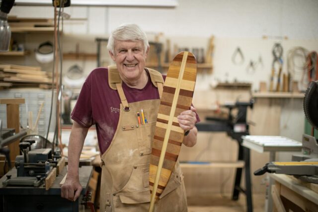Gerry in the woodworking shop at the Woods campus with one of the oars he makes
