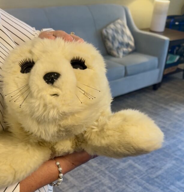 a person holding a realistic baby seal robot